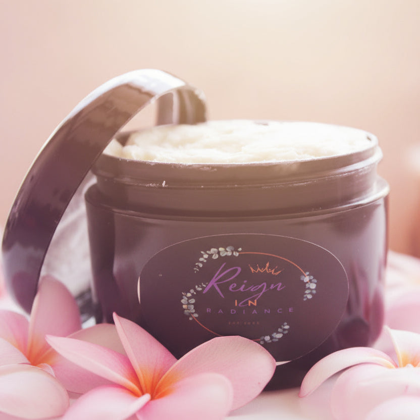 Black jar with a lid containing a white cream or paste, on a blurred background.